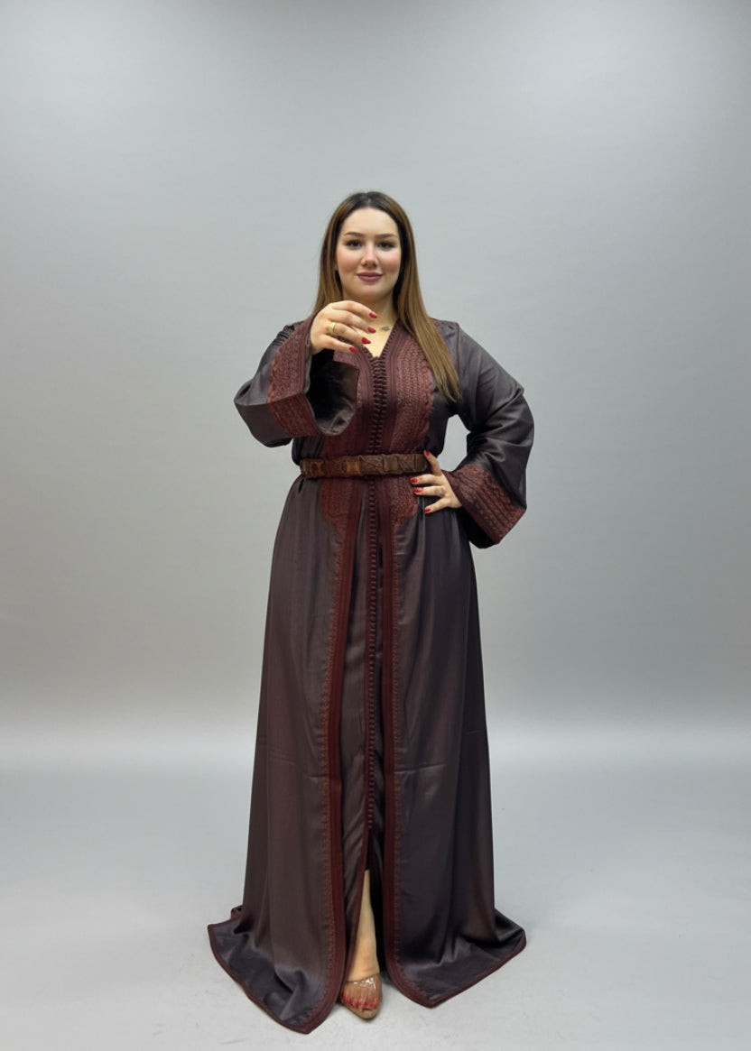 A woman modeling a dark brown traditional long kaftan with a matching belt.