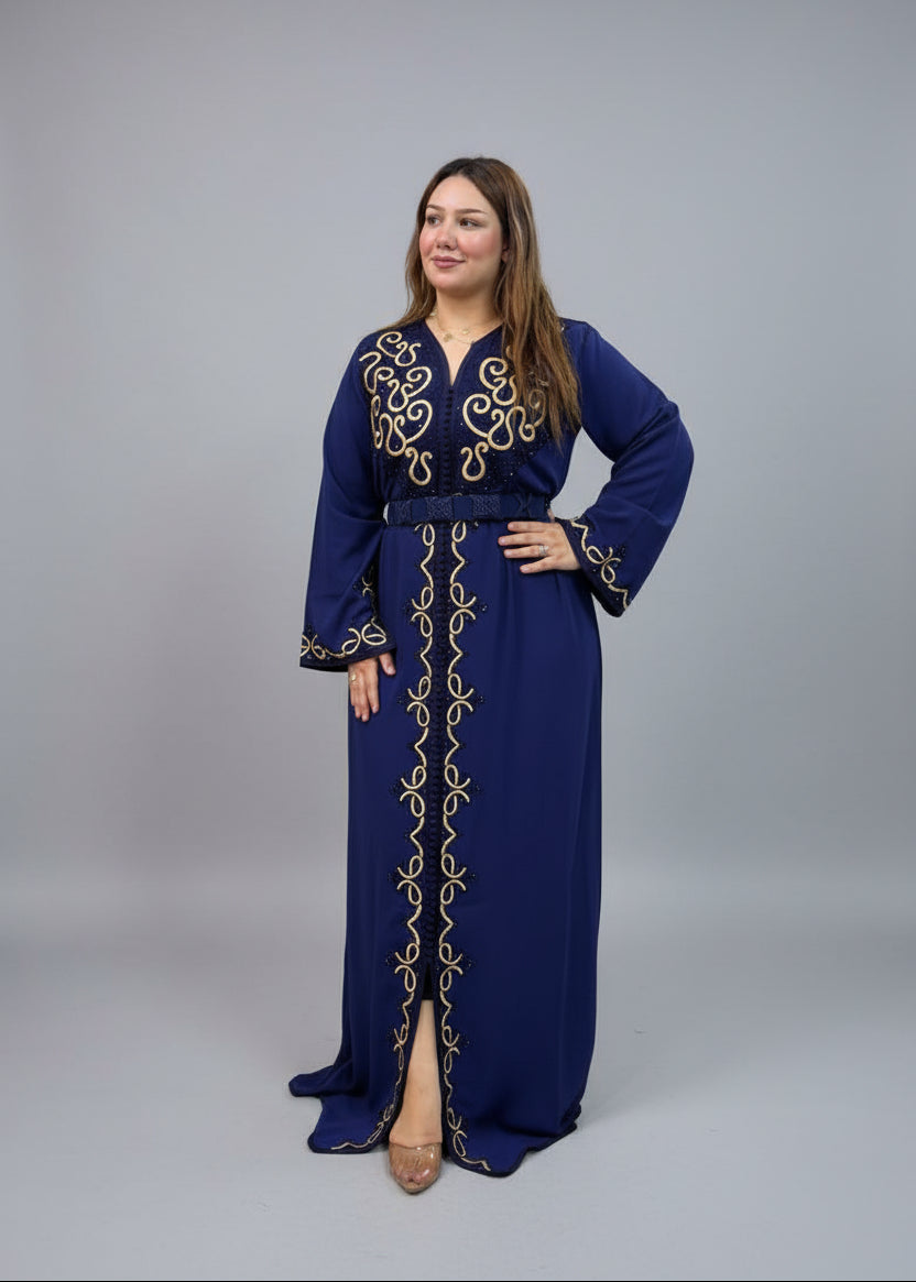 A woman modeling a navy blue long caftan dress with gold embroidery.