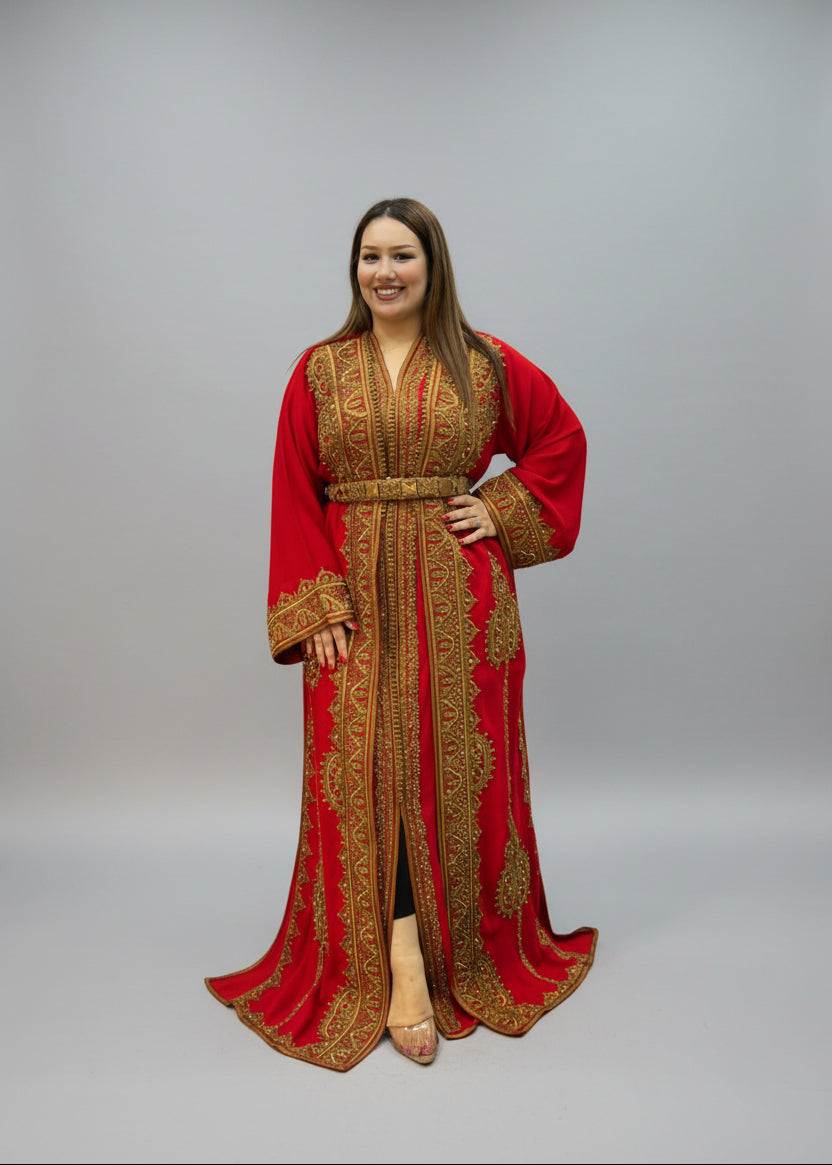 A woman modeling a long red kaftan dress with intricate gold embroidery,