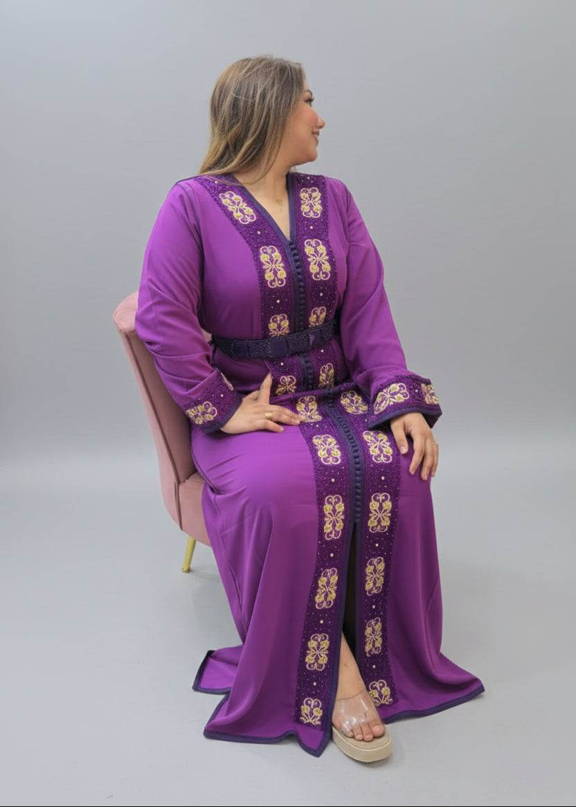 A woman wearing a purple long kaftan dress with gold and white embroidery.