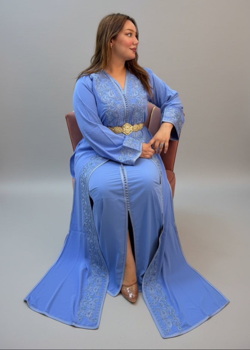 A woman wearing a light blue traditional long kaftan with gold embroidery .