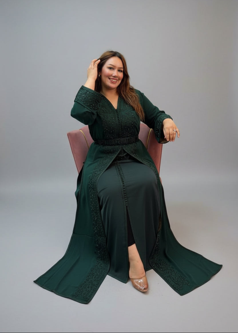 A woman wearing a dark green traditional long Kaftan with embroidered details.