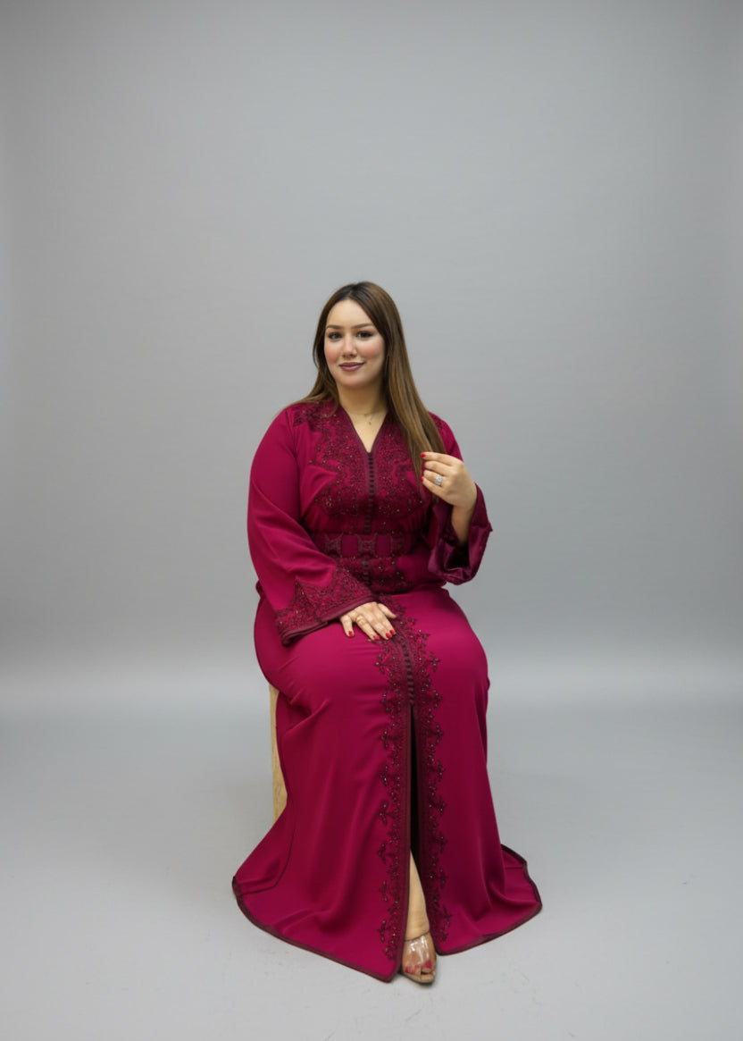 A woman wearing a long Kaftan embroidered dress .