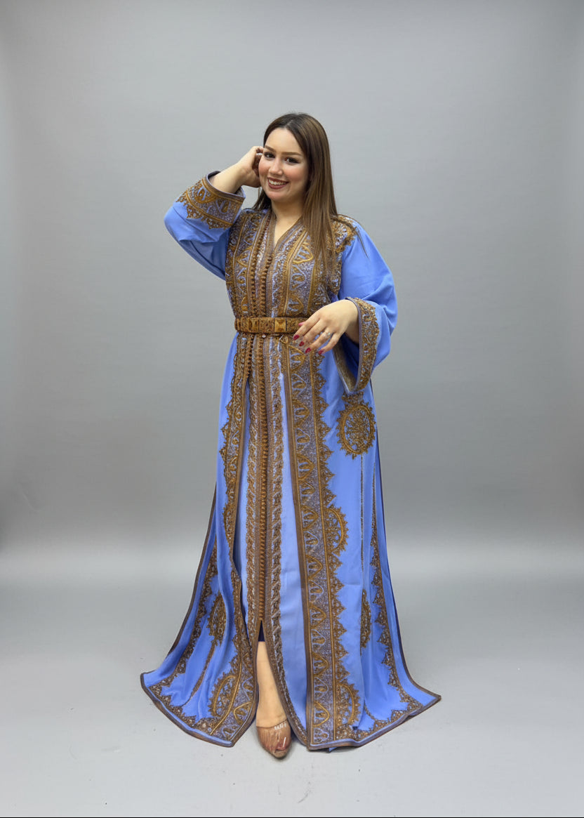 A woman modeling a long blue caftan with intricate gold embroidery.