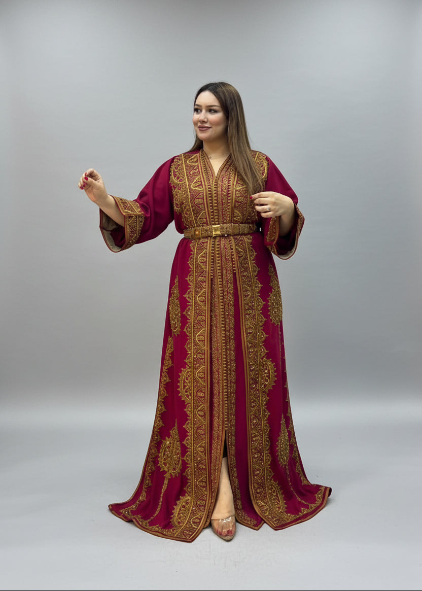 A woman modeling a long kaftan and gold embroidered.