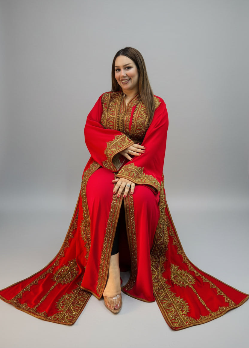 A woman wearing a vibrant red traditional kaftan with intricate gold embroidery.