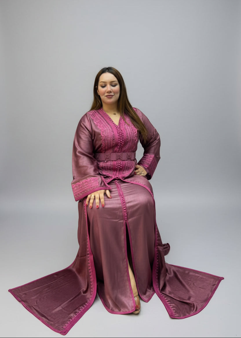 A woman wearing a long magenta-purple kaftan with a matching belt and long train.
