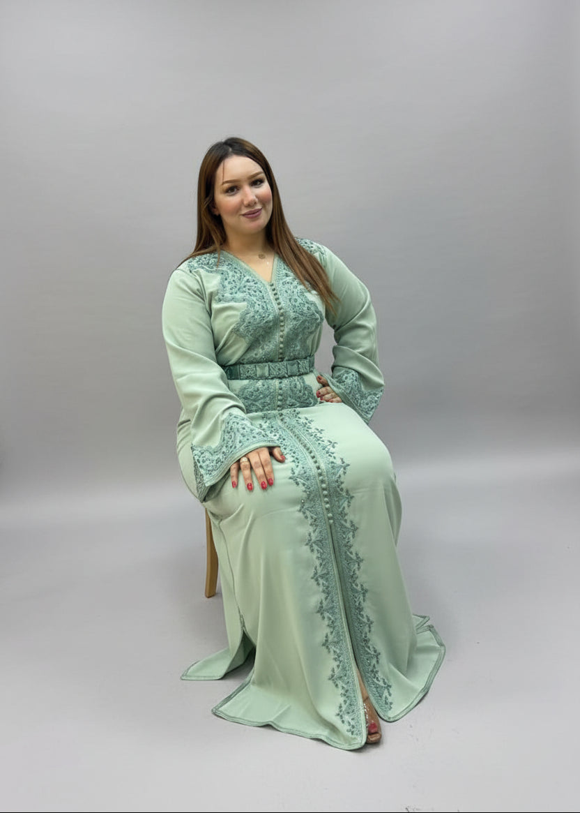 A woman wearing a mint green embroidered long kaftan.