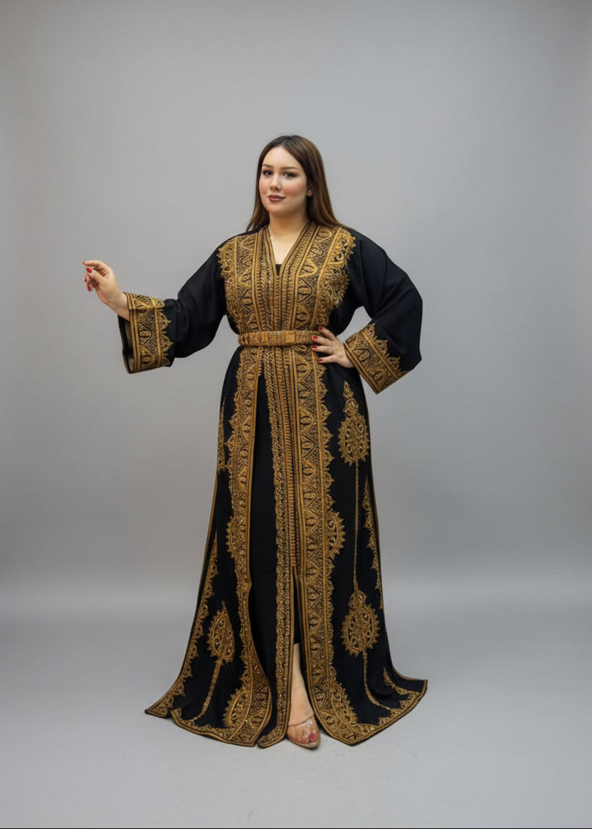 A woman modeling a long black Kaftan with ornate gold embroidery.