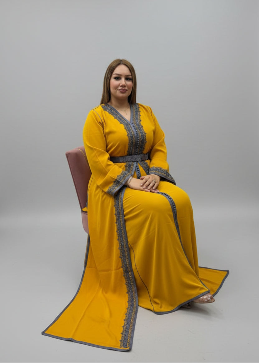 Woman in a yellow dress with gray trim sitting in a store.
"caftan dress"
"women's caftan"
"kaftan"