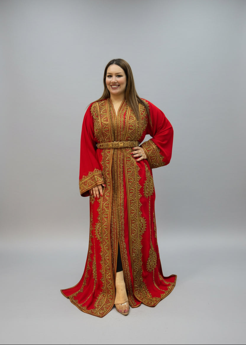 A woman modeling a long red kaftan dress with intricate gold embroidery, 