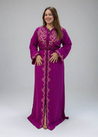 A woman modeling a magenta-purple Moroccan caftan with gold embroidery, 