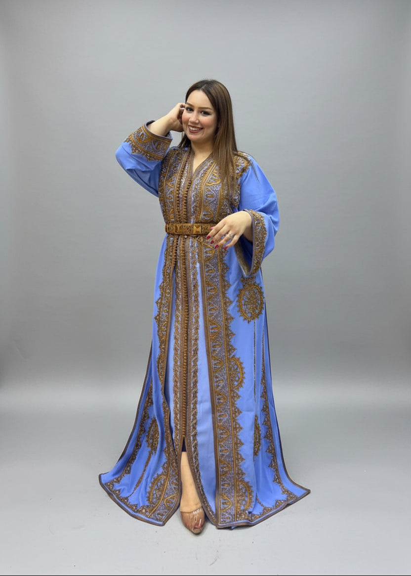 A woman modeling a long blue caftan with intricate gold embroidery.