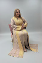 Woman in a beige and gold traditional outfit sitting in a store."kaftan dress""
"kaftan dresses"
"women kaftan"
"kaftan women"
"black kaftan"
"kaftan for women"
"men's kaftan"
"maxi kaftan"
"kaftan set"
"long kaftan"
"white kaftan"
"kaftan maxi dress"
"cotton kaftan"
"silk kaftan"
"blue kaftan"
"kaftan men"
"men kaftan"
"what is kaftan"
"caftan"
"moroccan kaftan"
"kaftan moroccan"
"kaftan top"
"embroidered kaftan"
"black kaftan dress"
"long kaftan dress"
"linen kaftan"
"abaya"
"kaftan abaya"