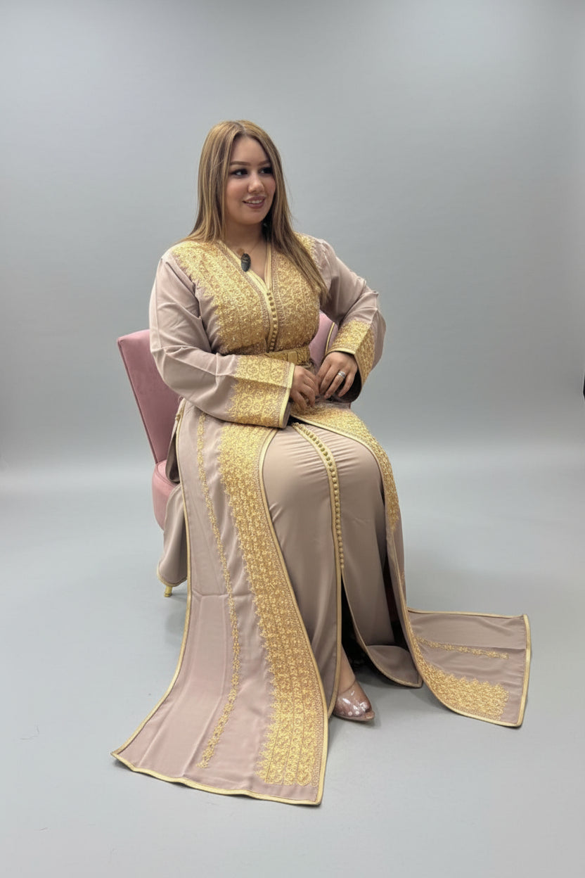 Woman in a beige and gold traditional outfit sitting in a store."kaftan dress""
"kaftan dresses"
"women kaftan"
"kaftan women"
"black kaftan"
"kaftan for women"
"men's kaftan"
"maxi kaftan"
"kaftan set"
"long kaftan"
"white kaftan"
"kaftan maxi dress"
"cotton kaftan"
"silk kaftan"
"blue kaftan"
"kaftan men"
"men kaftan"
"what is kaftan"
"caftan"
"moroccan kaftan"
"kaftan moroccan"
"kaftan top"
"embroidered kaftan"
"black kaftan dress"
"long kaftan dress"
"linen kaftan"
"abaya"
"kaftan abaya"