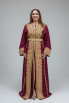Woman wearing a burgundy and gold dress in front of colorful fabric displays."kaftan dress""
"kaftan dresses"
"women kaftan"
"kaftan women"
"black kaftan"
"kaftan for women"
"men's kaftan"
"maxi kaftan"
"kaftan set"
"long kaftan"
"white kaftan"
"kaftan maxi dress"
"cotton kaftan"
"silk kaftan"
"blue kaftan"
"kaftan men"
"men kaftan"
"what is kaftan"
"caftan"
"moroccan kaftan"
"kaftan moroccan"
"kaftan top"
"embroidered kaftan"
"black kaftan dress"
"long kaftan dress"
"linen kaftan"
"abaya"
