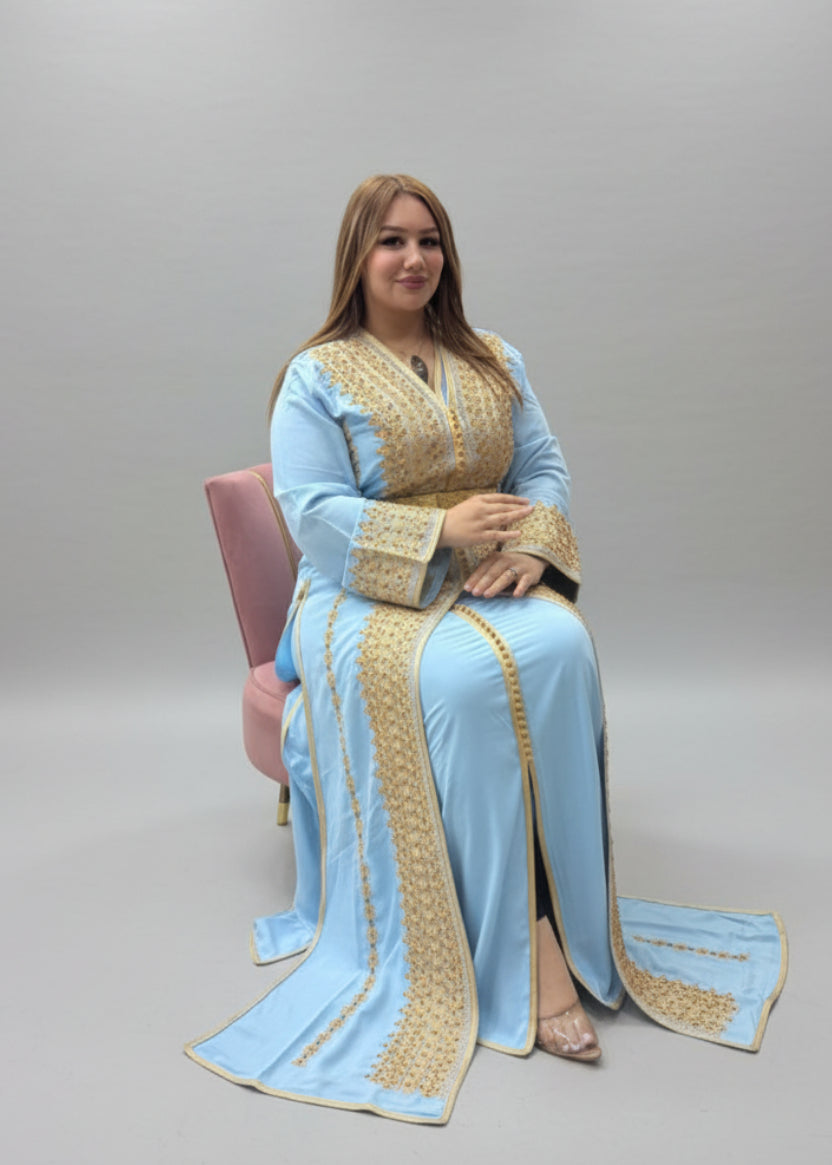 Woman in a light blue and gold traditional outfit sitting in a store."kaftan dress""
"kaftan dresses"
"women kaftan"
"kaftan women"
"black kaftan"
"kaftan for women"
"men's kaftan"
"maxi kaftan"
"kaftan set"
"long kaftan"
"white kaftan"
"kaftan maxi dress"
"cotton kaftan"
"silk kaftan"
"blue kaftan"
"kaftan men"
"men kaftan"
"what is kaftan"
"caftan"
"moroccan kaftan"
"kaftan moroccan"
"kaftan top"
"embroidered kaftan"
"black kaftan dress"
"long kaftan dress"
"linen kaftan"
"abaya"
"kaftan abaya"