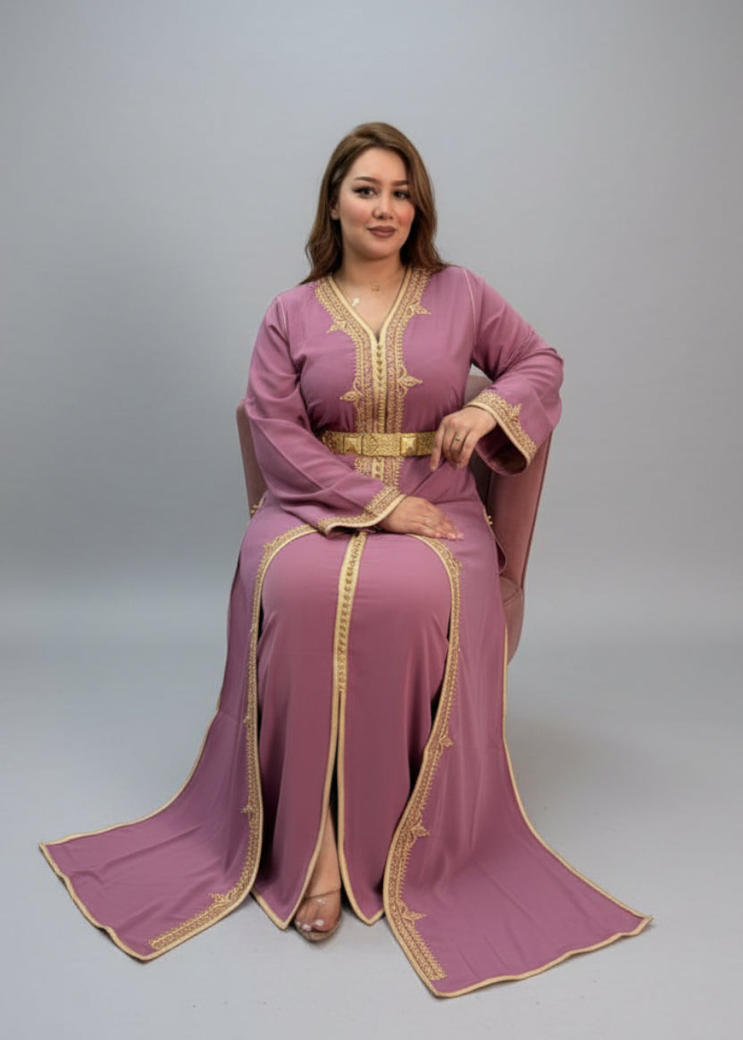 Woman in a pink traditional outfit with gold accents sitting in a store. "caftan dress"
"women's caftan"
"kaftan"
"cotton caftan"
"caftan moroccan"
"moroccan caftan"
"men's caftan"
"caftan for women"
"white caftan"
"blue caftan"
"what is caftan"
"caftan dresses"
"caftan men"
"silk caftan"
"vintage caftan"
"maxi dress"
"beach caftan"
"caftan maxi dress"
"caftan for men"
"what is a caftan"
"caftan cover up"
"kaftan dress"
"plus size caftan"
"caftan plus size"
"short caftan"
"linen caftan"
"womens caftan"