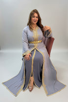 Woman wearing a gray dress with gold accents in a store setting "caftan dress"
"women's caftan"
"kaftan"
"cotton caftan"
"caftan moroccan"
"moroccan caftan"
"men's caftan"
"caftan for women"
"white caftan"
"blue caftan"
"what is caftan"
"caftan dresses"
"caftan men"
"silk caftan"
"vintage caftan"
"maxi dress"
"beach caftan"
"caftan maxi dress"
"caftan for men"
"what is a caftan"
"caftan cover up"
"kaftan dress"
"plus size caftan"
"caftan plus size"
"short caftan"
"linen caftan"
"womens caftan"
