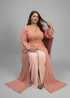 Woman in a peach dress with gold accents sitting in a store."caftan dress"
"women's caftan"
"kaftan"
"cotton caftan"
"caftan moroccan"
"moroccan caftan"
"men's caftan"
"caftan for women"
"white caftan"
"blue caftan"
"what is caftan"
"caftan dresses"
"caftan men"
"silk caftan"
"vintage caftan"
"maxi dress"
"beach caftan"
"caftan maxi dress"
"caftan for men"
"what is a caftan"
"caftan cover up"
"kaftan dress"
"plus size caftan"
"caftan plus size"
"short caftan"
"linen caftan"
"womens caftan"
"caftan meaning"