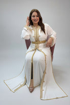 Woman in a white dress with gold accents in a store setting"caftan dress"
"women's caftan"
"kaftan"
"cotton caftan"
"caftan moroccan"
"moroccan caftan"
"men's caftan"
"caftan for women"
"white caftan"
"blue caftan"
"what is caftan"
"caftan dresses"
"caftan men"
"silk caftan"
"vintage caftan"
"maxi dress"
"beach caftan"
"caftan maxi dress"
"caftan for men"
"what is a caftan"
"caftan cover up"
"kaftan dress"
"plus size caftan"
"caftan plus size"
"short caftan"
"linen caftan"
"womens caftan"
"caftan meaning"
"