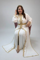 Woman in a white dress with gold accents in a store setting"caftan dress"
"women's caftan"
"kaftan"
"cotton caftan"
"caftan moroccan"
"moroccan caftan"
"men's caftan"
"caftan for women"
"white caftan"
"blue caftan"
"what is caftan"
"caftan dresses"
"caftan men"
"silk caftan"
"vintage caftan"
"maxi dress"
"beach caftan"
"caftan maxi dress"
"caftan for men"
"what is a caftan"
"caftan cover up"
"kaftan dress"
"plus size caftan"
"caftan plus size"
"short caftan"
"linen caftan"
"womens caftan"
"caftan meaning"
"