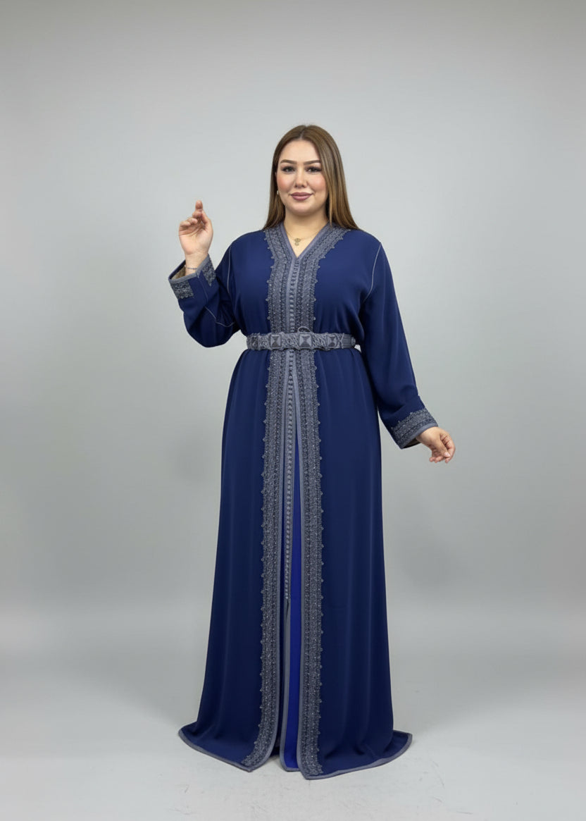 Woman in a blue dress standing in a clothing store with colorful garments in the background.
"caftan dress"
"women's caftan"
"kaftan"