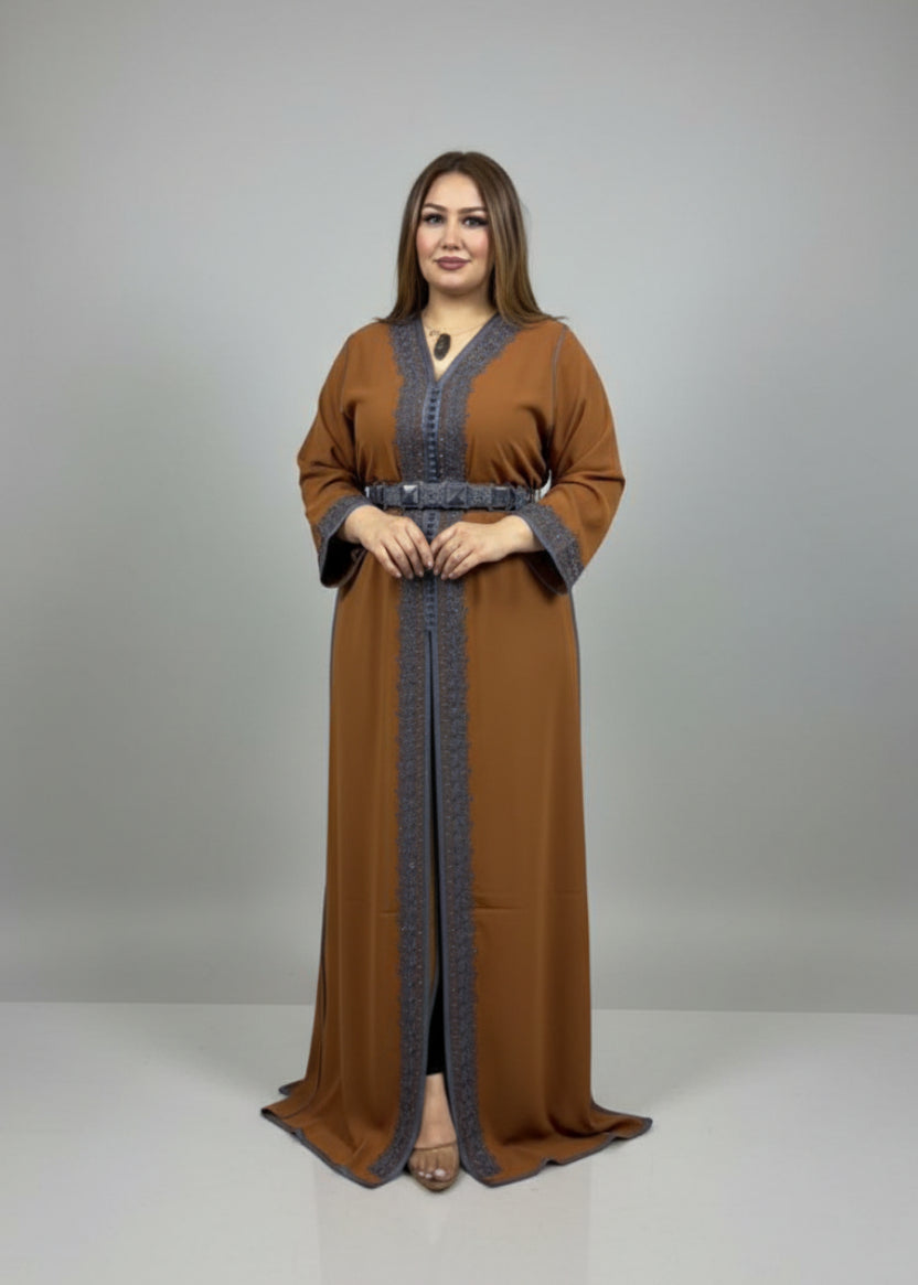 Woman wearing a long brown dress with intricate patterns in a fabric store.
"caftan dress"
"women's caftan"
"kaftan"
