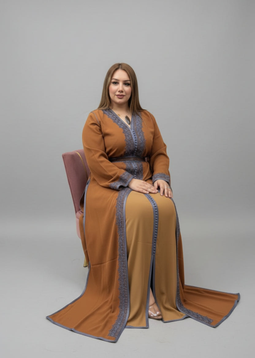 Woman wearing a brown traditional outfit with blue accents in a store setting.
"caftan dress"
"women's caftan"
"kaftan"
