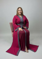 Woman in a red traditional outfit sitting in a store with fabric on shelves.
"caftan dress"
"women's caftan"
"kaftan"
"cotton caftan"
"caftan moroccan"