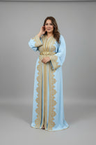 Woman wearing a light blue dress with gold embroidery in a fabric store."caftan dress"
"women's caftan"
"kaftan"
"cotton caftan"
"caftan moroccan"
"moroccan caftan"
"caftan for women"
"white caftan"
"blue caftan"
"what is caftan"
"caftan dresses"
"silk caftan"
"vintage caftan"
"maxi dress"
"beach caftan"
"caftan maxi dress"
"caftan for men"
"what is a caftan"
"caftan cover up"
"kaftan dress"
"plus size caftan"
"caftan plus size"
"short caftan"
"linen caftan"
"womens caftan"
"caftan meaning"
"caftan pattern"