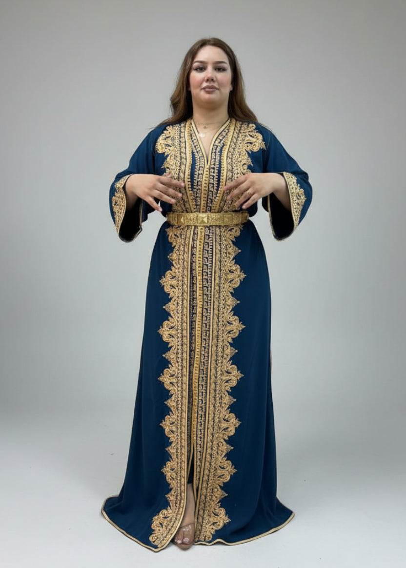 Woman wearing a blue and gold embroidered kaftan in a caftan store.
