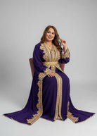 Woman wearing a purple dress with gold embroidery on a gray "caftan dress"
"women's caftan"
"kaftan"
"cotton caftan"
"caftan moroccan"
"moroccan caftan"
"caftan for women"
"white caftan"
"blue caftan"
"what is caftan"
"caftan dresses"
"silk caftan"
"vintage caftan"
"maxi dress"
"beach caftan"
"caftan maxi dress"
"caftan for men"
"what is a caftan"
"caftan cover up"
"kaftan dress"
"plus size caftan"
"caftan plus size"
"short caftan"
"linen caftan"
"womens caftan"
"caftan meaning"
"caftan pattern"