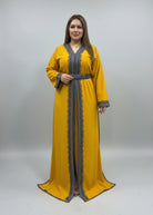 Woman wearing a yellow dress with intricate patterns in a fabric store.
"caftan dress"
"women's caftan"
"kaftan"
"cotton caftan"
"caftan moroccan"